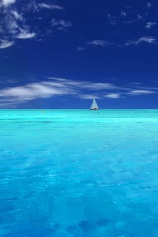 青い海と沖に浮かぶヨット